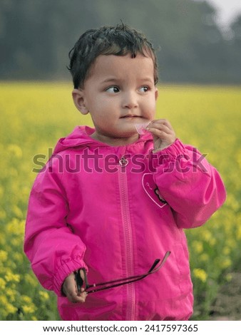 Cute baby in beautiful mustard field. Portrait of a kid