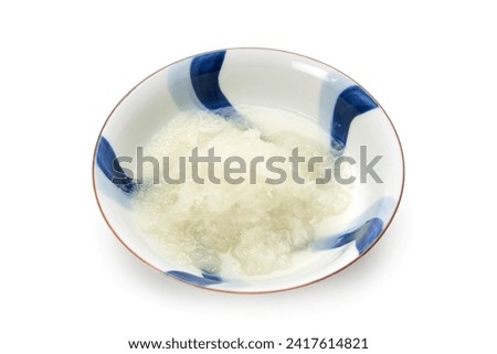 Grated radish on a small plate on a white background