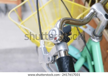 Green Women's City Bike with photo focus on the bike bell, handlebar and braking system