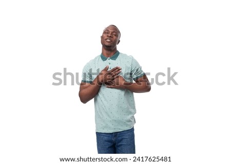 young slender american man dressed in a t-shirt smiles cutely on a white background
