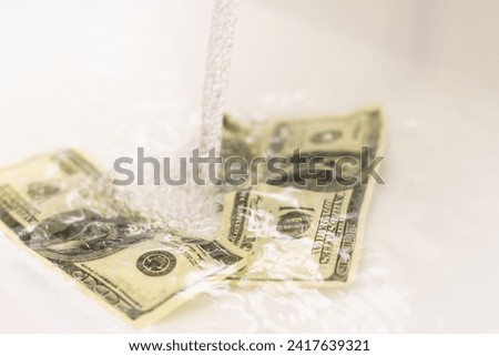 Money is thrown away in the sink. This photo concept illustrates the financial condition of a business that is failing or going bankrupt so that it only wastes money without results Royalty-Free Stock Photo #2417639321