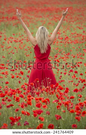 Beautiful blonde woman with red dress, in the middle of a poppy field 