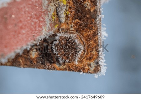 The rusty metal, covered with frost, froze. Royalty-Free Stock Photo #2417649609
