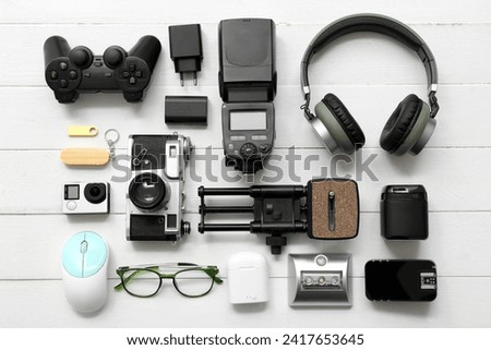 Composition with different modern gadgets on light wooden background