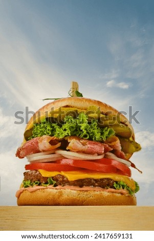 Low angle view of beef burger with bacon, cheese and vegetables Royalty-Free Stock Photo #2417659131