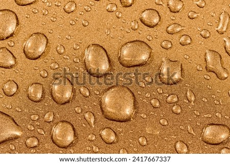 Abstract background with water drops on brass textured surface