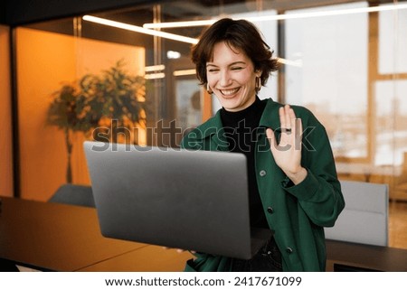 Gen Z business woman working on laptop. Flexible office for startups. Creative female looking into the computer at coworking space. Small online business owner Royalty-Free Stock Photo #2417671099