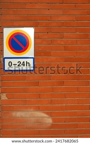Sign parking prohibited from 0 to 24 hours on a brick wall