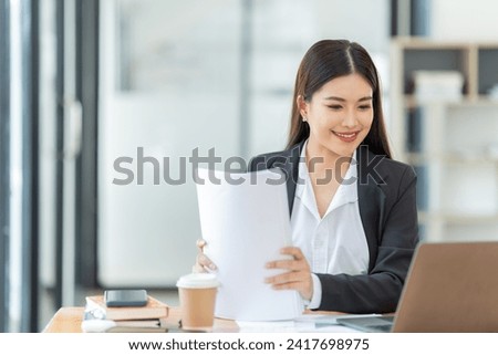 Young happy business woman working with tablet and document in corporate office
