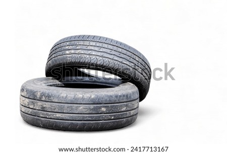Isolated on a white background two black old car tires with copy space. Reuse of worn out rubber tires. Disposal of used tires. Production of secondary rubber from tires Royalty-Free Stock Photo #2417713167