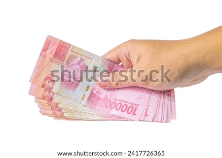 Hand Holding Indonesian Rupiah Isolated On White Background, Hand Holding Money Isolated On White Background Royalty-Free Stock Photo #2417726365
