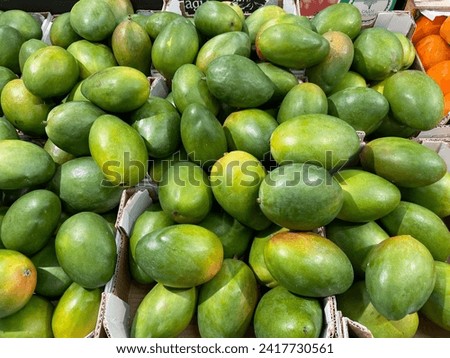 Green mango on the market counter. great background Royalty-Free Stock Photo #2417730561