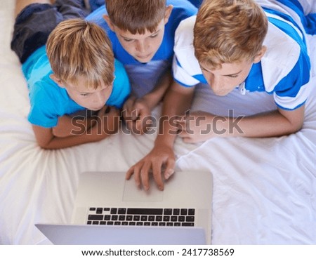 Children, home and playing on laptop in bedroom, care and excited for online videos in house. Young brothers, mousepad and streaming cartoons on bed for bonding together, love and relax on weekend