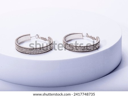 Studio shot close-up photo of silver hoop earrings, isolated on white