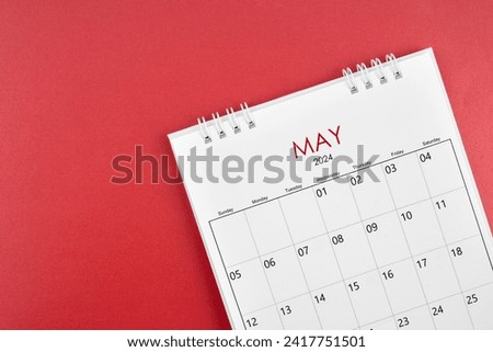 May 2024 desk calendar on red color background.