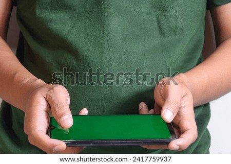 closeup of hands holding smart phones with green screen and showing playing game isolated on white background, person sharing media transfer data files, touching monitor, showing using device, free co