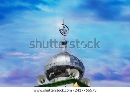 The metal dome of the mosque is accented with the Arabic writing Allah, which means God