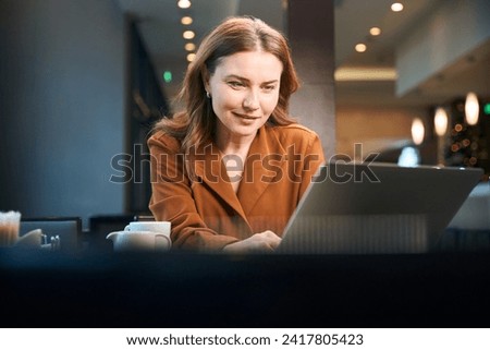 Close up photo of sitting woman working on the laptop