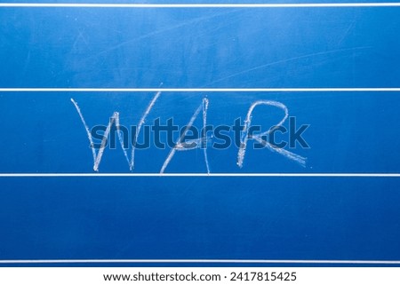 The inscription WAR in white chalk on a blue drawing board