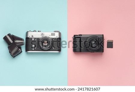 Modern digital and film cameras on a blue pink background. Top view