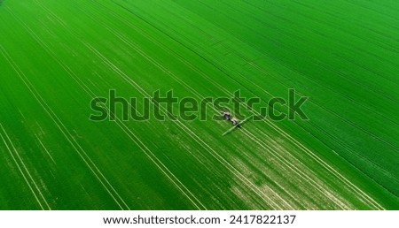 Agriculture Aerial Of Tractor Spraying Farm Land With Pesticides, agricultural chemicals. Drone shoot of farming Equipment. Food Modification GMO Farming Concept. Royalty-Free Stock Photo #2417822137