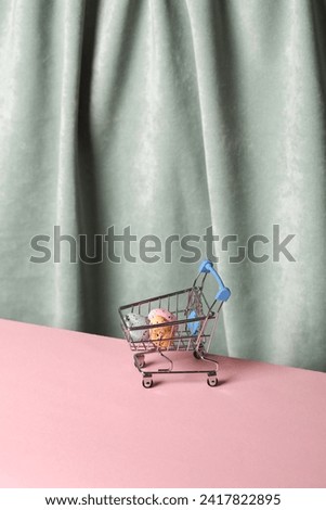Shopping trolley with easter eggs against the background of a curtain. Aesthetic still life. Minimalism. Holiday mood