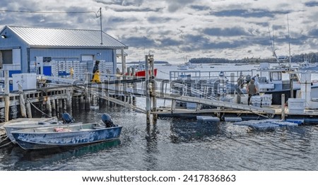 Lobster Dock:  A fishing boat at a working New England dock unloads lobsters in holding crates which are later submerged near the pier.
 Royalty-Free Stock Photo #2417836863