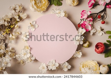 Decorative podium with pink cherry flowers on pastel pink background, top view, flat lay. Place for product presentation. Creative product platform