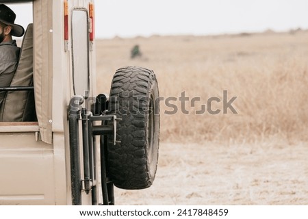 Close up picture of spare tyre in a safari jeep in Africa. Savannah blur background perfect for copy space d