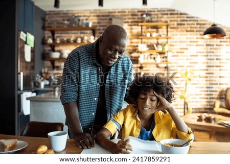 Grandfather doing homework with grandson at home Royalty-Free Stock Photo #2417859291