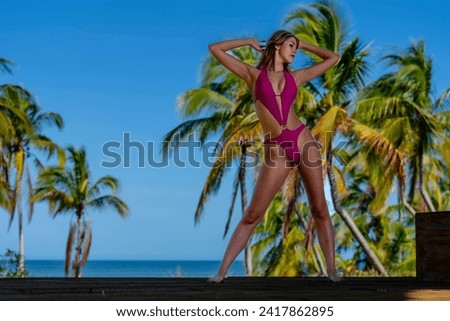 In the enchanting Caribbean, a radiant woman strikes a pose on a stunning beach, her silhouette graced by the vivid blue sky, embodying timeless beauty and coastal allure. Royalty-Free Stock Photo #2417862895