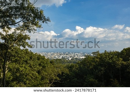 This photo captures a sweeping panoramic vista of the Chiang Mai cityscape as seen from a distant vantage point.