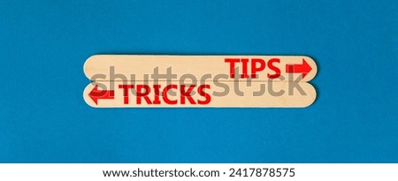 Tips and tricks symbol. Concept word Tips and tricks on beautiful wooden stick. Beautiful blue table blue background. Business and Tips and tricks concept. Copy space.