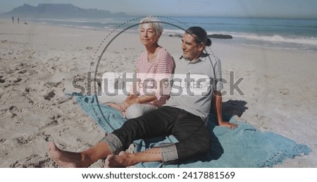 Image of speech bubble with thumbs up and like numbers over senior couple on beach. digital interface, social media and global networking concept digitally generated image.