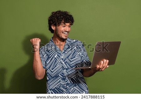 Photo of impressed lucky man dressed print shirt winning game modern gadget empty space isolated green color background Royalty-Free Stock Photo #2417888115