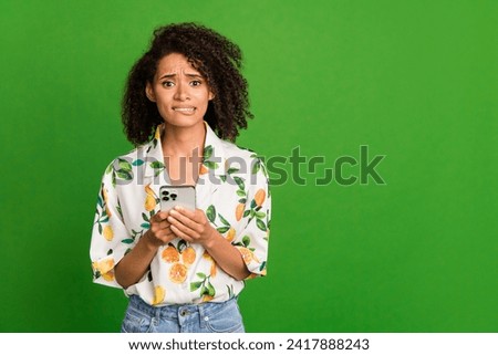 Photo of uncertain stressed woman dressed print shirt communicating modern gadget empty space isolated green color background