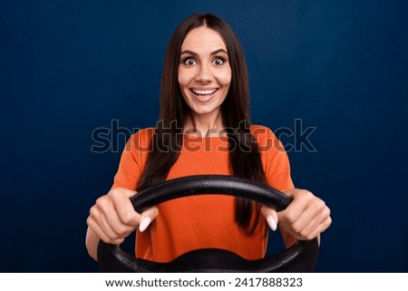 Photo of impressed excited lady wear orange t-shirt driving auto isolated dark blue color background