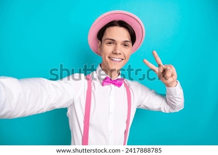 Photo portrait of pretty young male take selfie photo show v-sign wear trendy pink outfit isolated on cyan color background