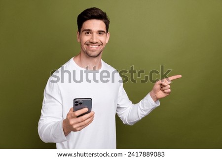 Portrait of attractive person hold smart phone indicate finger empty space isolated on khaki color background