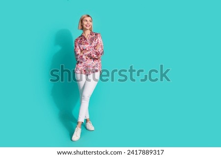 Full length photo of nice young lady folded arms look empty space wear trendy pink print garment isolated on cyan color background
