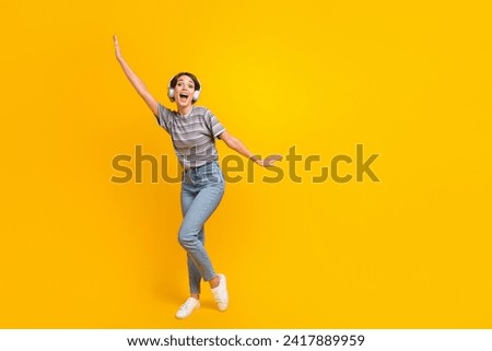 Full length photo of satisfied overjoyed person dancing listen music headphones empty space isolated on yellow color background