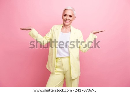 Photo of aged employer woman in suit holding two arms promoting two services with different advantages isolated on pink color background