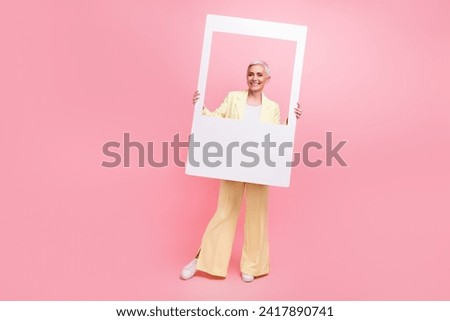 Full size photo of good mood woman dressed yellow suit posing in photo frame make instant picture isolated on pink color background