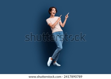 Full body photo of pretty young girl point excited empty space wear trendy white outfit isolated on dark blue color background