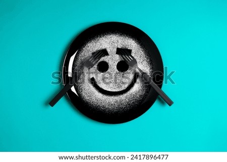 Smiling face, concept made with plate and flour, cyan background, star shaped eyes, black plate, happy mood, facial expressions, forks in the shape of arms with different positions