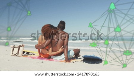 Image of spinning networks with social media digital icons over couple embracing on beach. digital interface, social media and global networking concept digitally generated image.