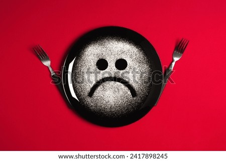 Sad face, concept made with plate and flour, red background, star shaped eyes, black plate, happy mood, facial expressions, forks in the shape of arms with different positions