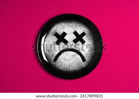 Sad face, concept made with plate and flour, red background, x-shaped eyes, black plate, happy mood, facial expressions
