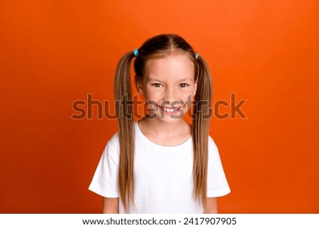 Photo of positive adorable schoolkid beaming smile good mood look camera isolated on orange color background