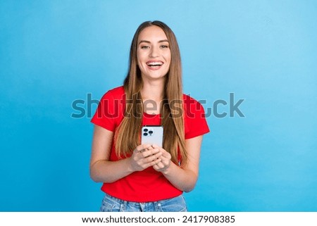 Photo of positive adorable girl influencer popular blogger use modern device apple iphone isolated on blue color background